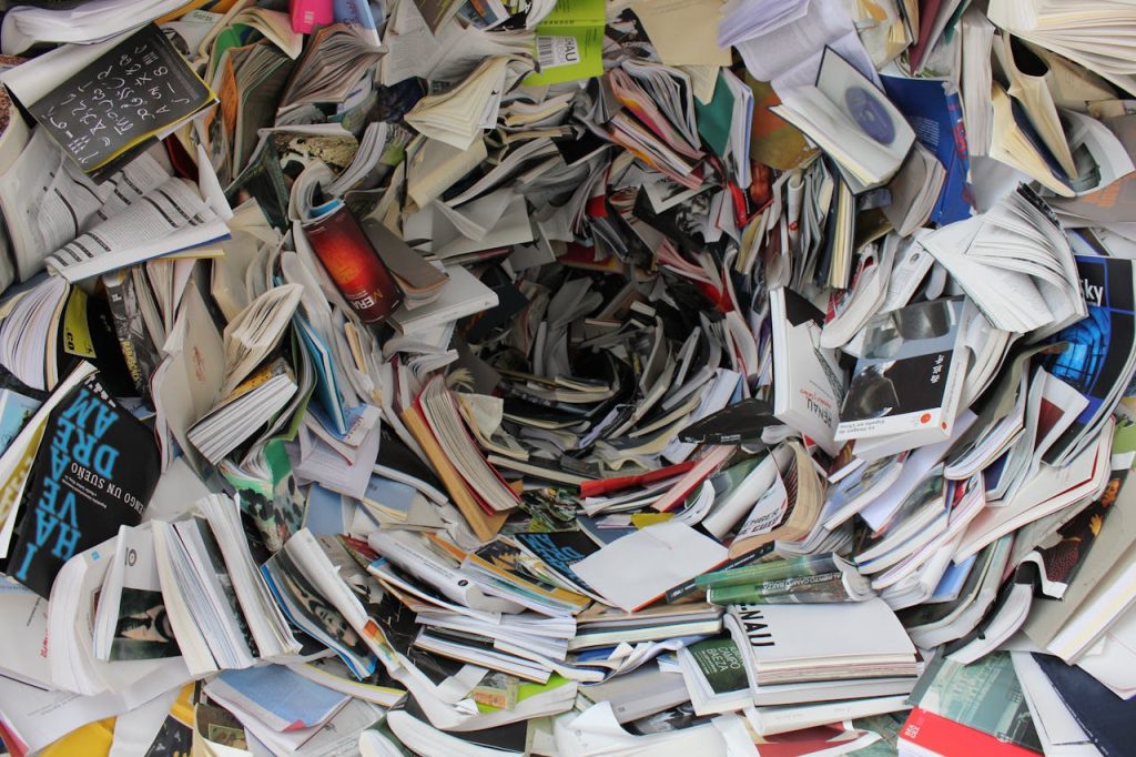 A whirlwind of books and papers creating a chaotic visual. Ideal for concepts of disorder or information overload.